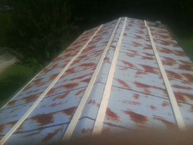 Rusted metal roof panels with new wood purlins before replacement — Storm Damage Roof Repair in Chestnut Hill by Roofing Brothers
