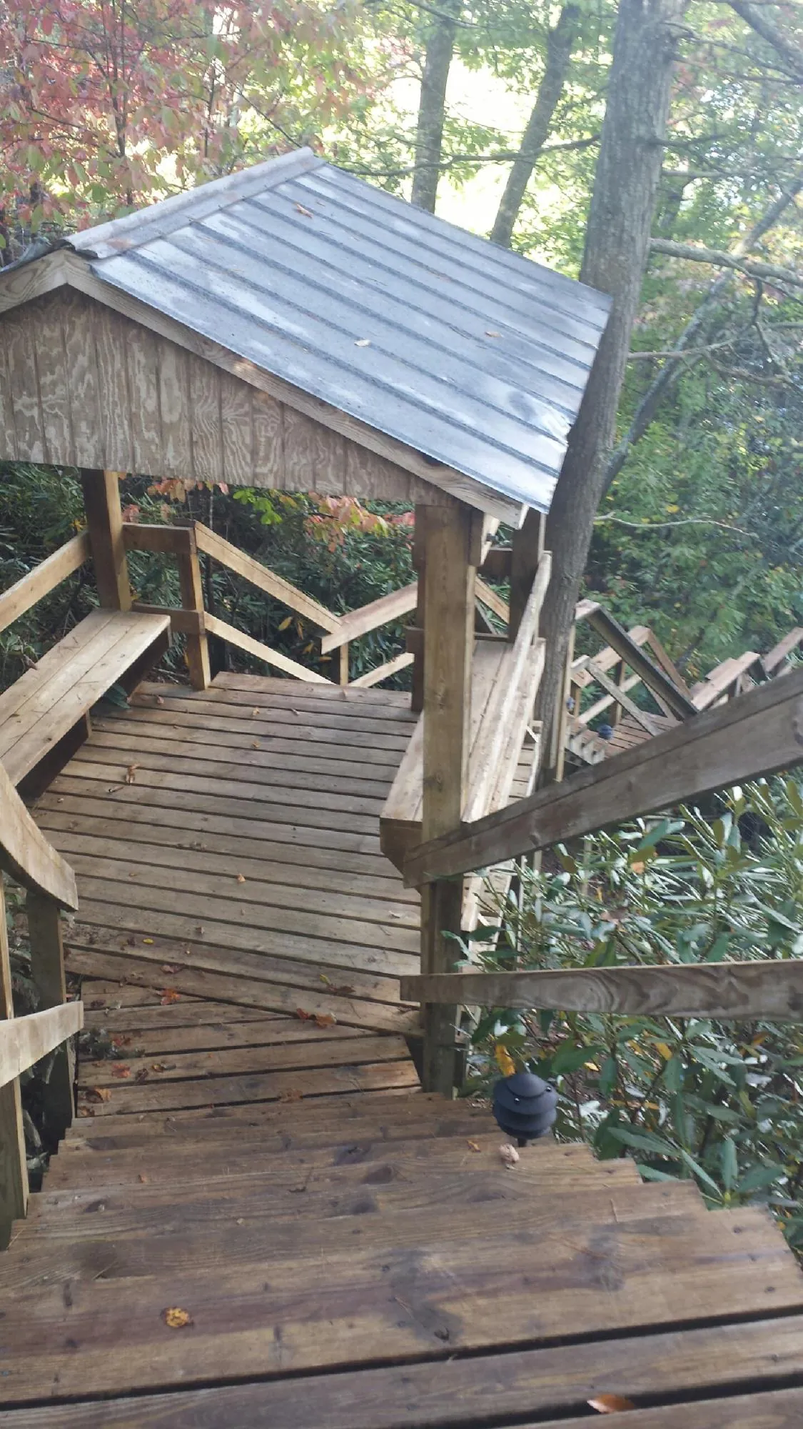 Metal roofed shelter over wooden steps on a wooded walkway — Skylight Repair & Installation work by our crew in Chestnut Hill