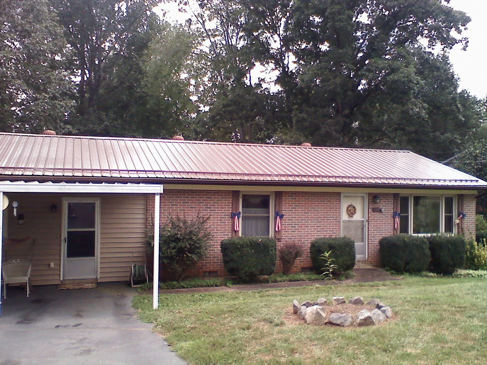 Bronze metal roof and carport on a brick ranch home — Roof Repair work by our crew in Chestnut Hill